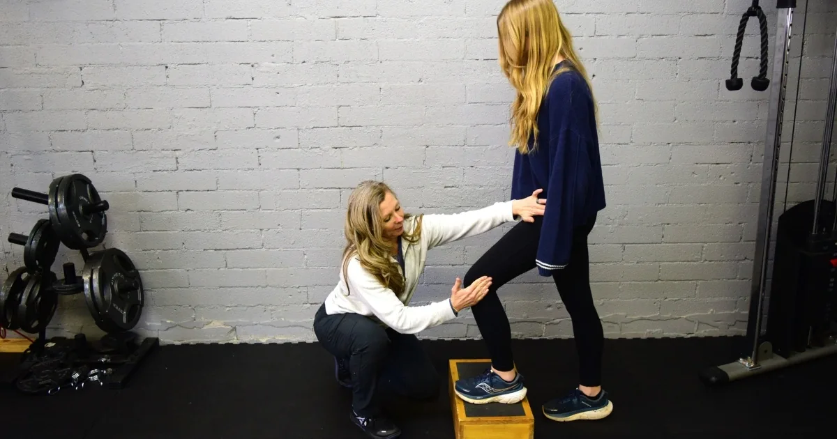 Dr. Crystal Geer coaching a patient through a step-up onto a plyo box