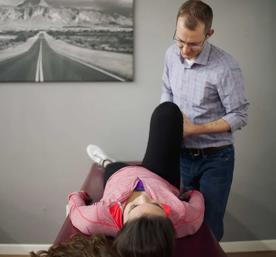 Dr. Jordan Williams assessing a patient's hamstring with a straight-leg raise