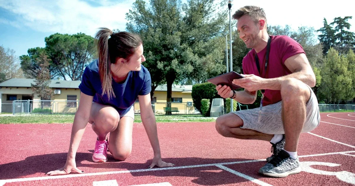 A coach recording a runner's stride on a track