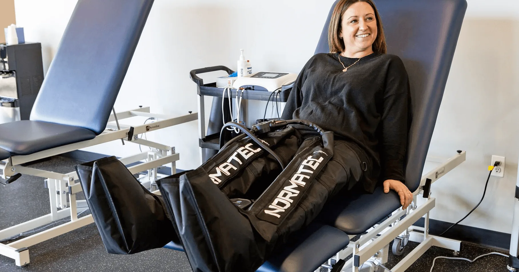 A patient relaxing in NormaTec compression boots in the Proof recovery bay